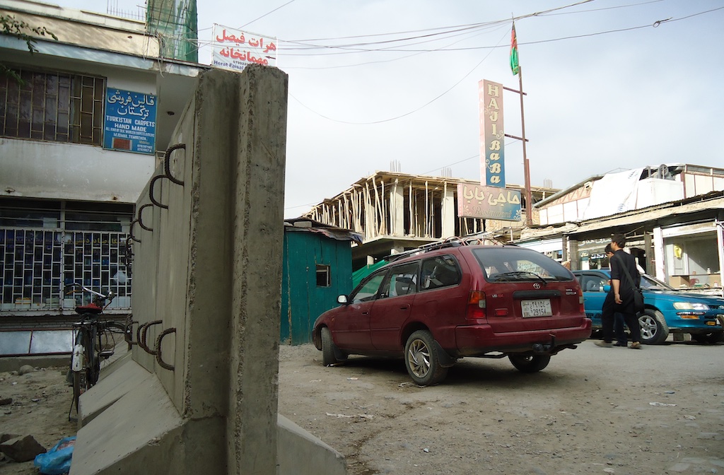 Red car next to a concrete wall in Kabul