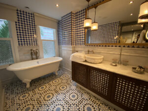 White clawfoot tub in a blue-and-white tiled bathroom