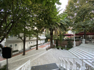 Steps leading down to a hotel courtyard with trees and a grey building nearby