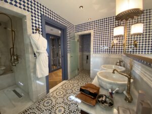 Ottoman style bathroom with tile floors, marble shower and sink