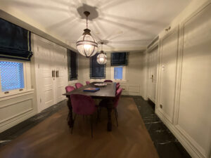 Dining room with a brown table and eight pink chairs