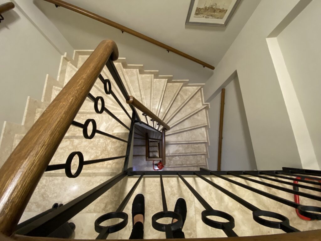 Winding marble staircase with wood railing