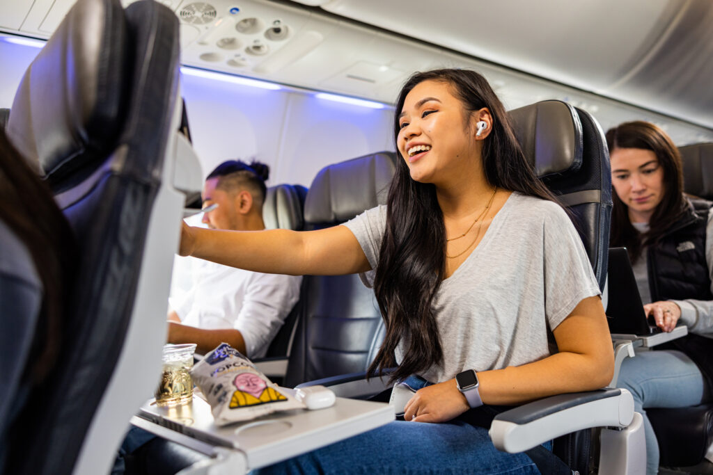 Woman sitting in an airplane seating with food in front of her