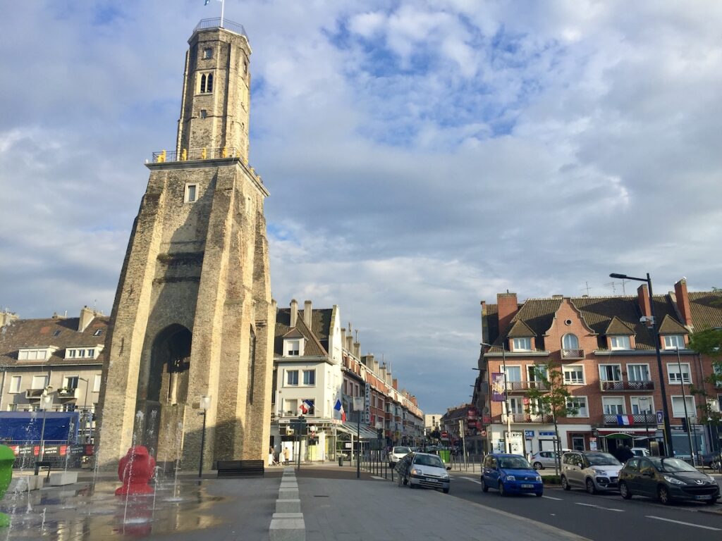 Large statue in small town France, surrounded by other buildings