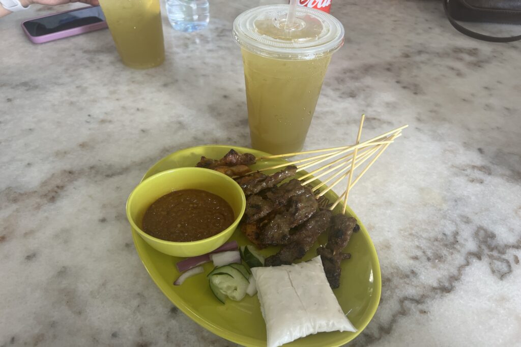 Example of how Singapore's food is overrated: A plate of chicken satay with rice and a bowl of peanut sauce